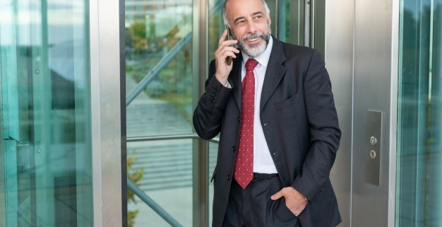 Hombre junto a ascensor con movil