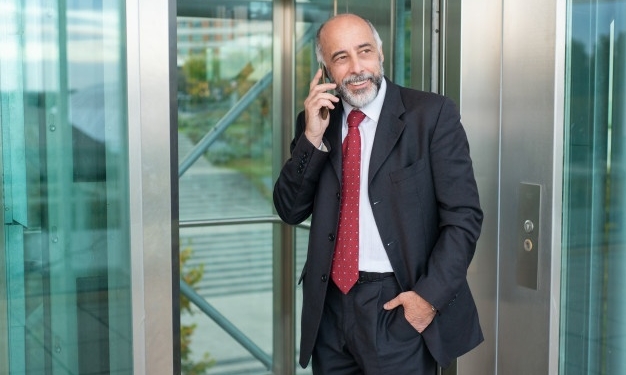 Hombre junto a ascensor con movil